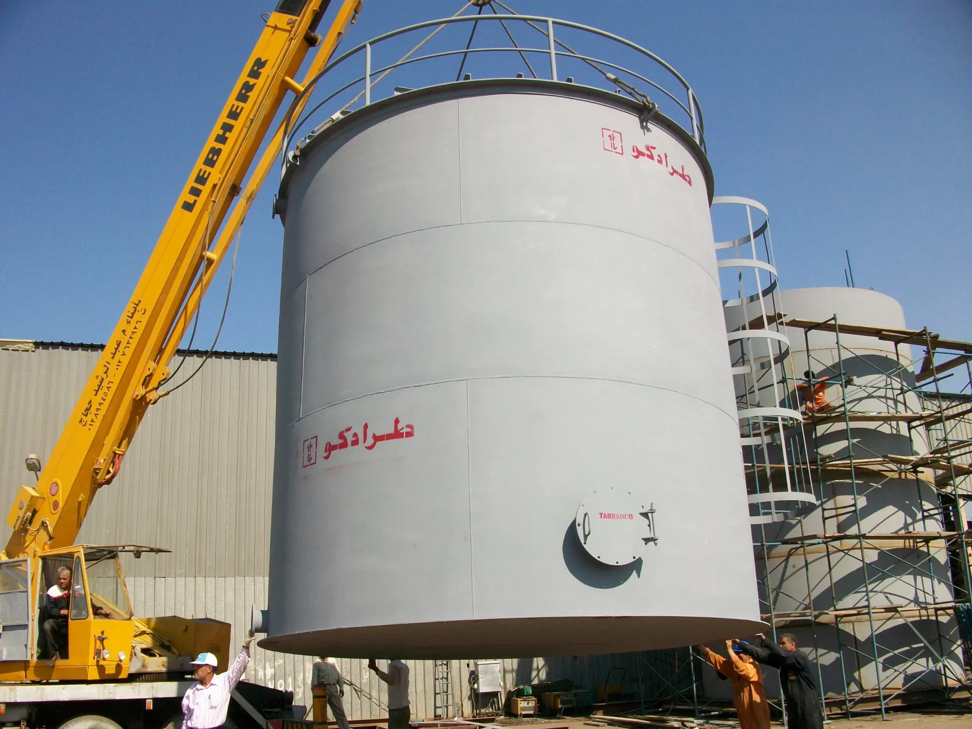 TARRADCO-branded vertical storage tank lifted into position during erection
